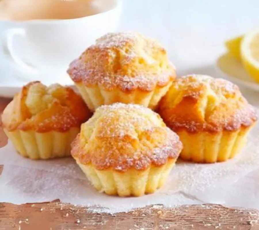 Muffins délicieux au fromage blanc et au citron, disposés sur une assiette rustique et garnis de tranches de citron frais